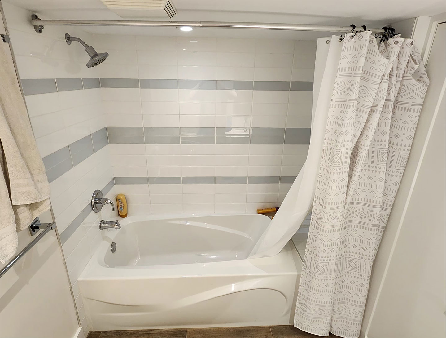Bathroom renovation before with a white tub and shower curtain