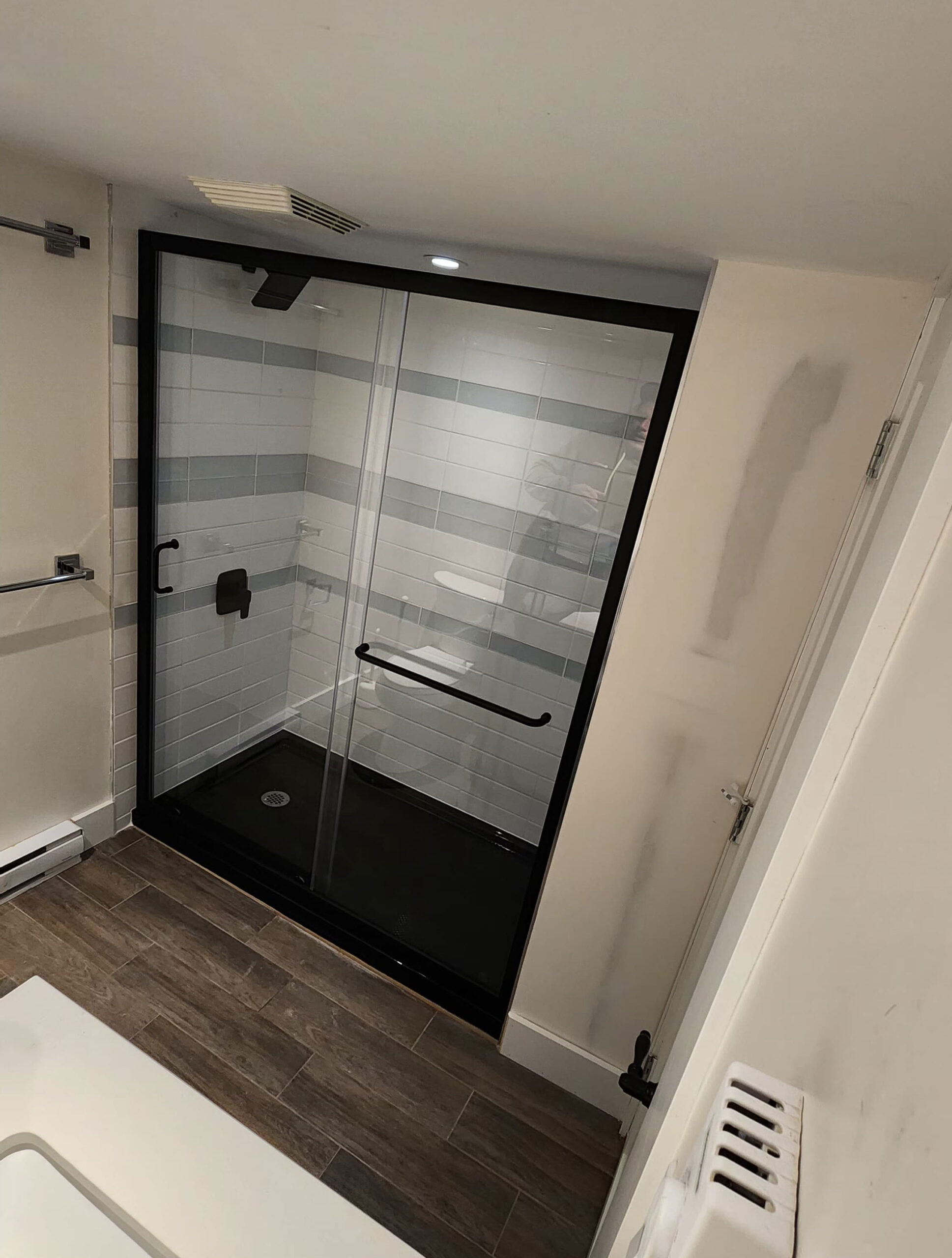 Brand new full shower with glass doors installed taken at a 45 degree angle